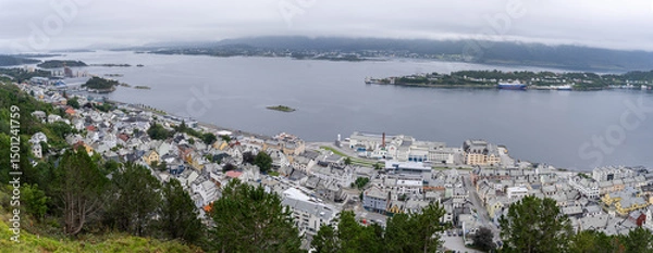 Fototapeta View of the port of Alesund on the west coast of Norway, with the island of Hessa in the background under a cloudy sky seen from Mount Aksla