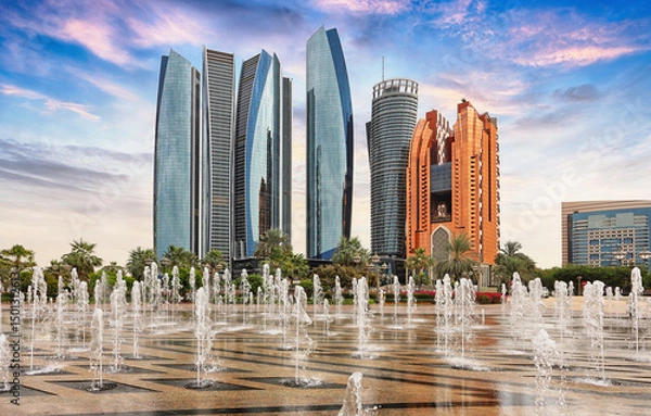 Obraz Skyscrapers in Abu Dhabi at dramatic sunset with fountain; United Arab Emirates