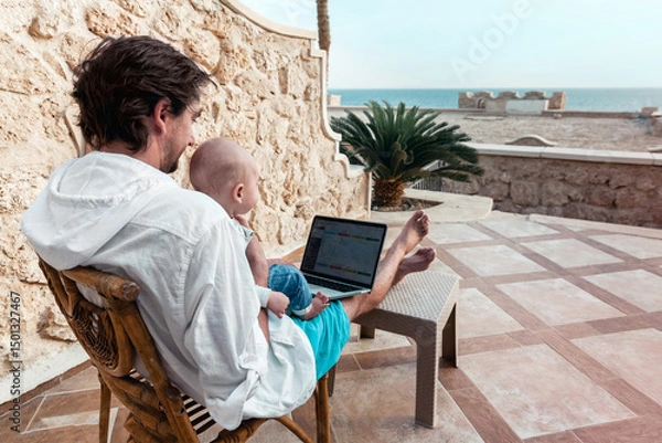 Fototapeta dad and his little son with a laptop are resting and working as a freelancer on vacation