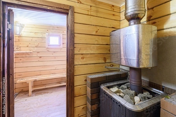 Fototapeta cozy sauna room with light wooden walls and benches. A stone heater stands in the corner, ready to provide warmth.