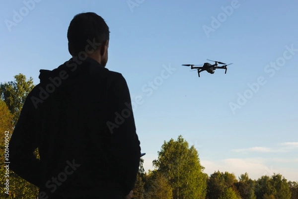 Fototapeta Dron, operator drona podczas pracy. Nagrywanie filmów z lotu ptaka dronem. Dron w rolnictwie. Filmy z góry. 