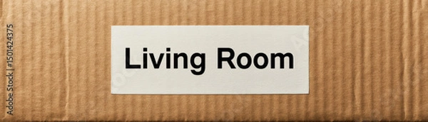 Fototapeta Closeup photo of cardboard box with label reading Living Room it, suggesting storage or organization home setting