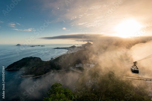 Fototapeta Famous View of Rio de Janeiro Coast from the Sugarloaf Mountain Under Clouds on Sunset and Cable Car Approaching