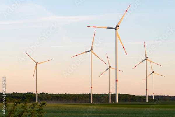 Obraz Wind turbines during sunset. Beautiful landscape with a wind power plant in Germany. Green and futuristic energy generation.