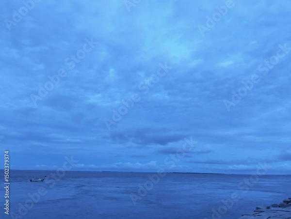Fototapeta The sky is cloudy and the ocean is calm, Calm ocean waves rolling onto sandy beach under cloudy sky scenic view from above nature landscape seascape coastal scene