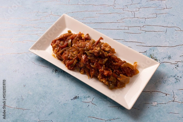 Fototapeta Lebanese moussaka stew served on a rectangular white ceramic plate.
