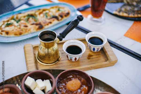 Fototapeta Traditional Lebanese breakfast with coffee, mezze, and bread on table.
