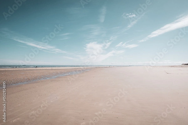 Fototapeta Wide Sandy Beach with Ocean and Horizon – Tranquil Coastal Scene Under Blue Sky