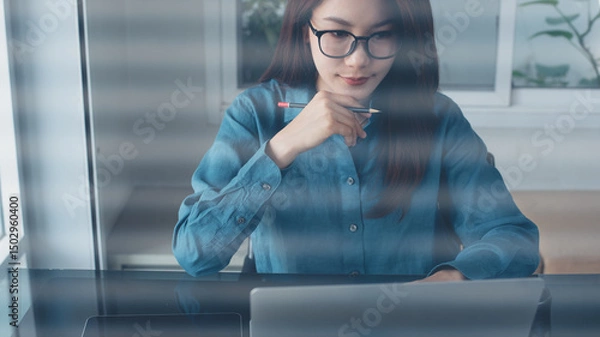 Obraz Young smart business woman working on laptop computer at office. Confident businesswoman using laptop for online meeting, looking at computer screen, webinar, video conference, remote work
