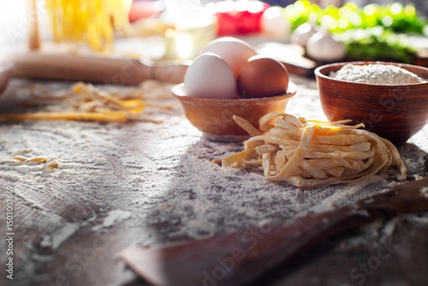 Obraz Portion of homemade noodles on floured kitchen table cooking background