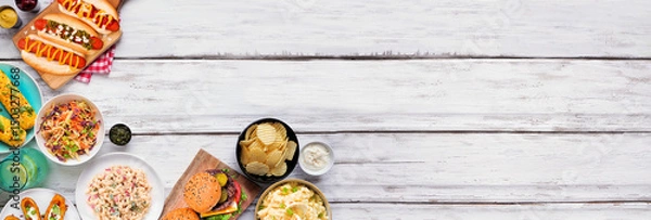 Obraz Summer food table scene with hot dogs, hamburger and sides. Top view corner border over a white wood banner background. Copy space.