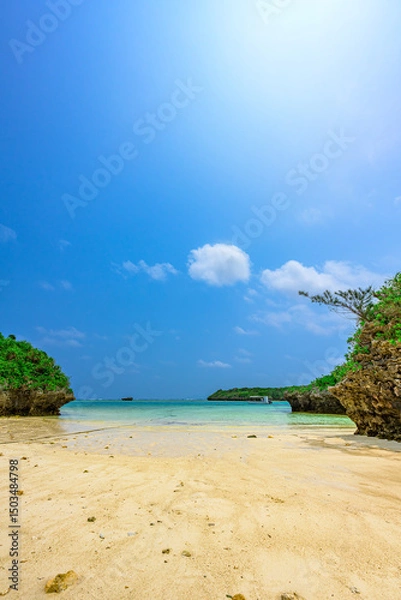 Obraz  石垣島の透明な海に浮かぶ小さな緑の奇岩　青い空とエメラルドグリーンの海