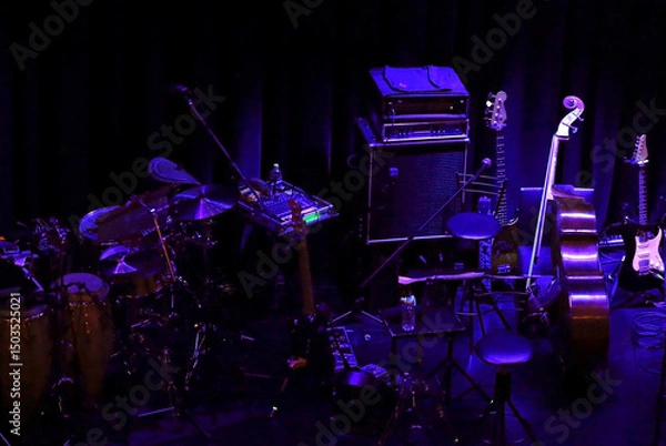 Obraz Various musical instruments placed on the stage of a dimly lit live music venue before the show begins