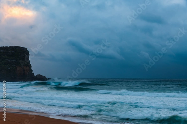 Fototapeta Moody sunrise with waves at the seaside