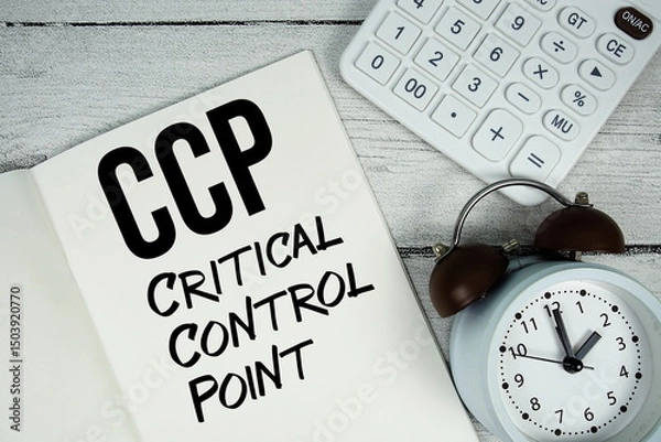 Fototapeta CCP Critical Control Point text on paper notebook page with alarm clock and calculator on wooden background