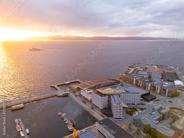 Fototapeta Trondheim, Norway, sunset over the fjord, Munkholmen and the new development area near the harbor