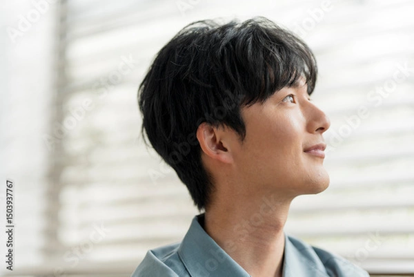 Fototapeta 微笑んでいる若い日本人男性の横顔。