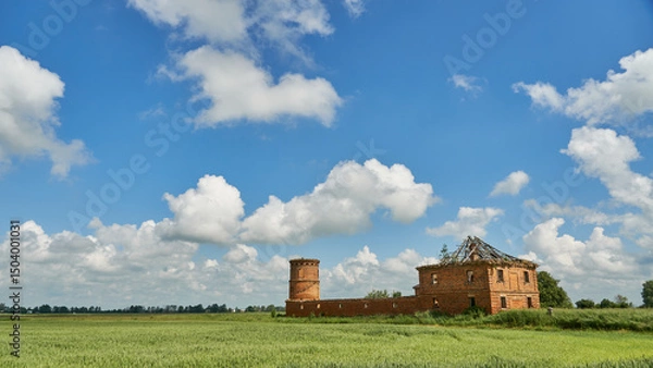 Fototapeta ruins of an old castle against a background of blue sky and clouds. Historical buildings in Belarus.