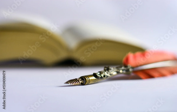 Obraz a red pen and an old book on a white table