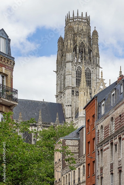 Fototapeta The spire of Saint-Ouen Abbey towering above the surrounding houses