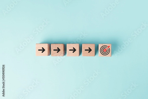 Obraz Cube wood block on pastel blue background with arrow symbol and arrow on target icon in concept of progress planning strategy for target goal objective achievement.