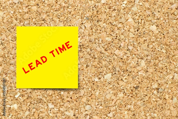 Fototapeta Yellow note paper with word lead time on cork board background with copy space