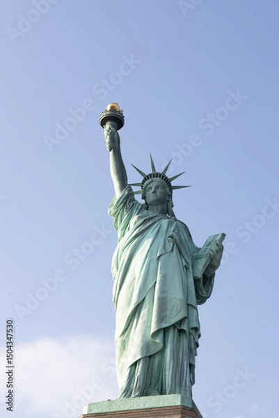 Fototapeta Statue of Liberty in New York City on a clear day. Iconic American symbol captured with bright sky and strong lighting.