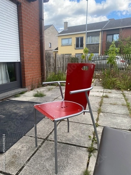Obraz old red chair standing in the backyard of the house