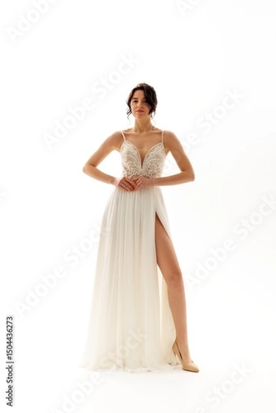 Fototapeta Elegant bride showcasing a stunning white gown with intricate detailing in a bright studio setting