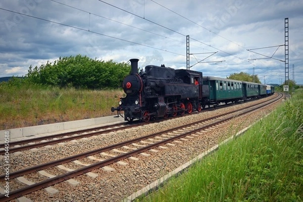 Obraz Old Czech historical steam train with wagons driving on the tracks for a trip. Concept for railways and history.