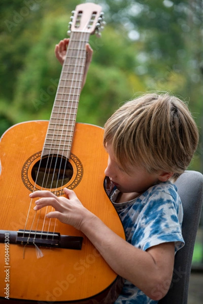 Obraz Curious child playing classical guitar