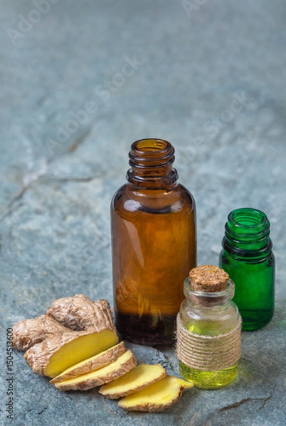 Fototapeta Bottles of essential oils with fresh ginger slices