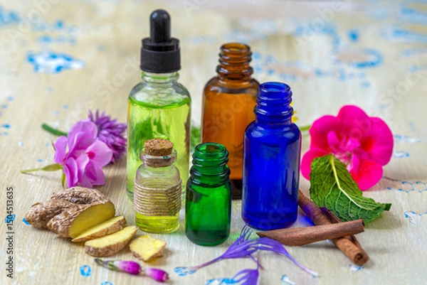 Fototapeta Essential oils and herbs arranged on a table