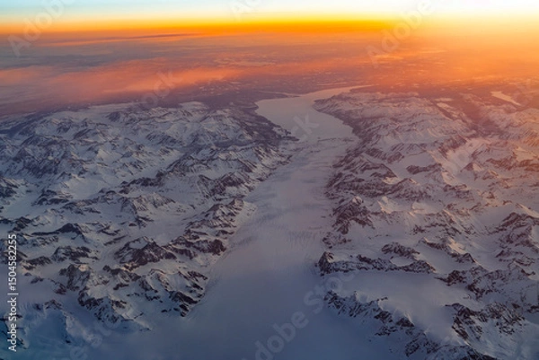 Fototapeta Aerial view of snow mountain and frozen river in colorful morning sunlight in Alaska