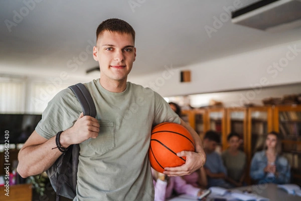 Obraz handsome man student stand with backpack and basket ball in library