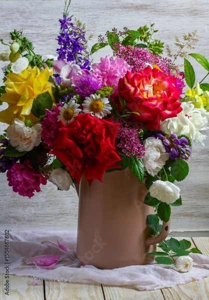 Fototapeta A bouquet of different flowers, roses, peonies, lupines, daisies, dilphinium, snapdragon and others in an old teapot.