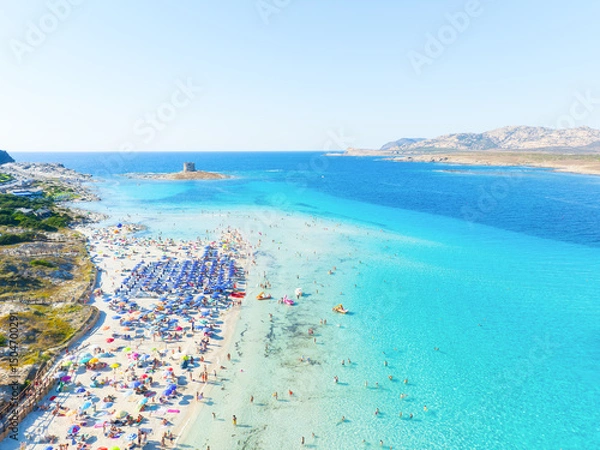 Fototapeta Beach La Pelosa, Sardinia, Italy. Summer vacation and rest. Beach, people and umbrellas. Top view from drone at the beach and azure sea. Background, wallpaper, postcards.