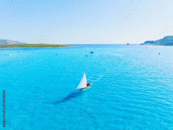 Fototapeta Summertime vacation. Sailing yacht at sea. Drone view on the yacht. .Sea and waves from top view. View on the coast from drone. Background, wallpaper, postcards.
