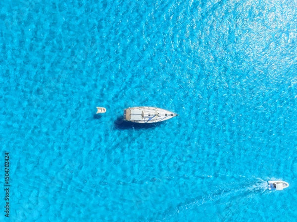 Fototapeta Summertime vacation. Sailing yacht at sea. Drone view on the yacht. .Sea and waves from top view. View on the coast from drone. Background, wallpaper, postcards.