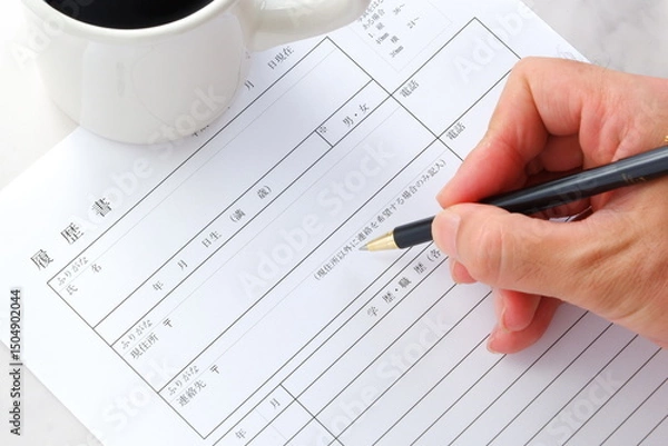 Fototapeta 就職活動（就活）のために、コーヒーを飲みながら、履歴書を作成する
