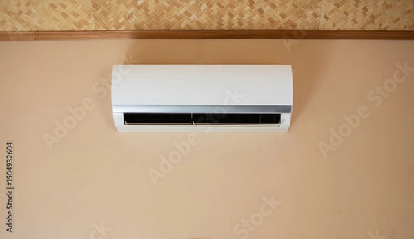 Fototapeta The air conditioner is installed inside the light yellow wall.
