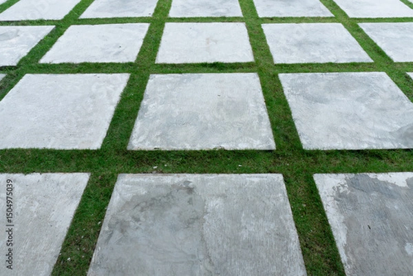 Obraz Geometric paving blocks with green grass in between, creating a modern and natural landscape design for outdoor paths, gardens, or minimalist courtyards.