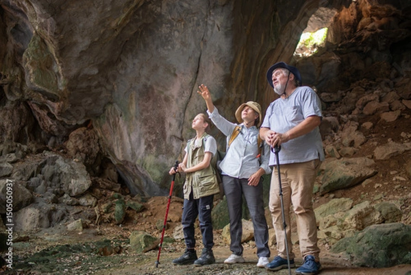 Fototapeta Tourist trekking with backpack and using a walking stick, gesturing forward suggesting of adventure or discovery in cave mysterious and ancient outdoor adventure concept.