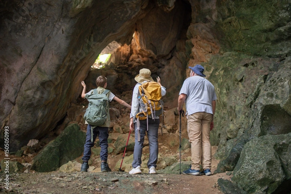 Fototapeta Tourist trekking with backpack and using a walking stick, gesturing forward suggesting of adventure or discovery in cave mysterious and ancient outdoor adventure concept.