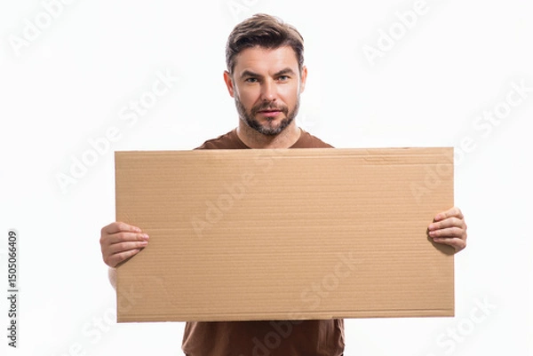 Fototapeta Handsome man holding empty board isolated on studio background. Guy showing blank signboard with copyspace. Idea offer. Your advertisement. Blank advertising board with empty space for text, mock up.