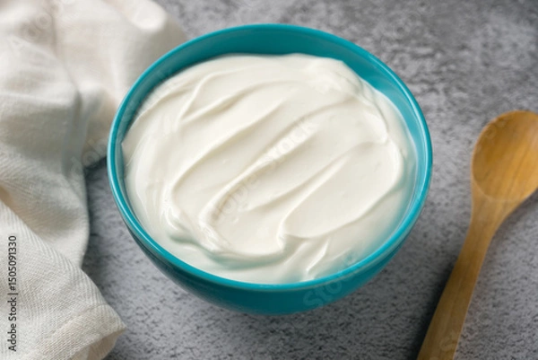 Fototapeta Top view of yogurt in bowl on grey stone table. Healthy eating concept