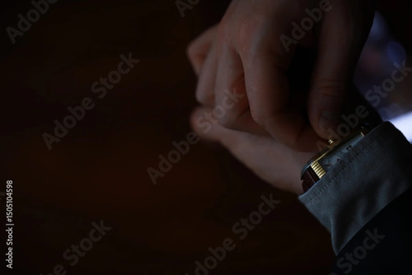 Obraz Close-Up of Businessman Adjusting His Wristwatch in Low Light Setting