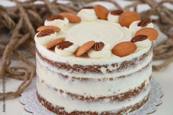 Fototapeta Delicious Carrot Cake with Nut Decorations spiced cake layers covered in smooth cream cheese frosting closeup side view of classic and delicious cafe cake