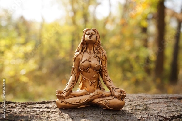 Fototapeta A Buddha figure on a background of autumn leaves. The female image.