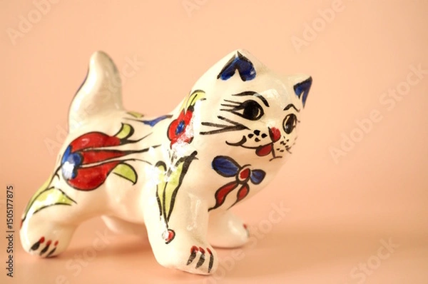 Fototapeta A cat figurine with a pattern on a pink background.